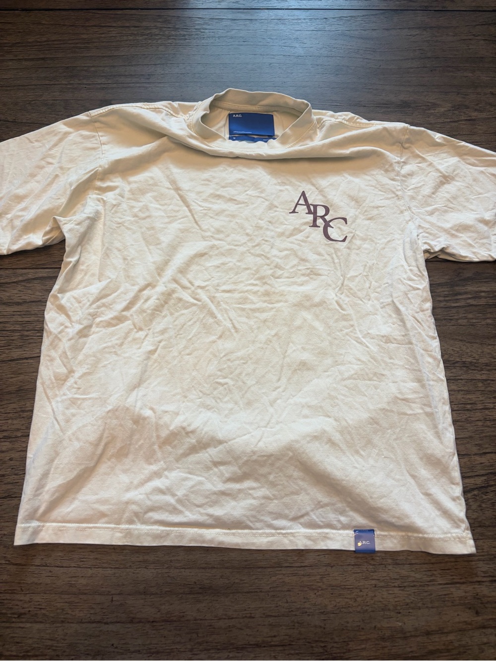 A.R.C. Men’s Cream Short Sleeve Tee with Purple ARC Logo